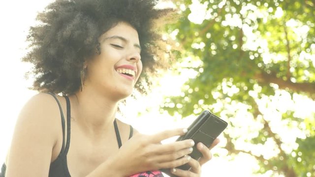 Young attractive woman with smartphone smiling and texting