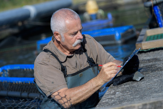 senior man managing his fish farm