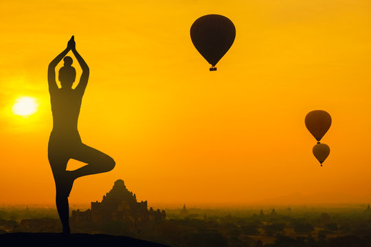 Silhouette yoga pose woman standing on the mountain sunset in Old Bagan pagoda Bagan Mandalay Myanmar