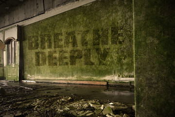 text breathe deeply on the dirty wall in an abandoned ruined house