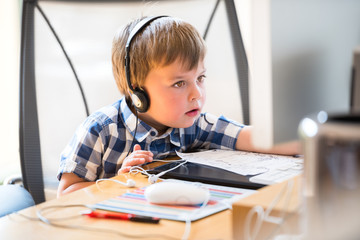 Kid wearing headphones while using computer