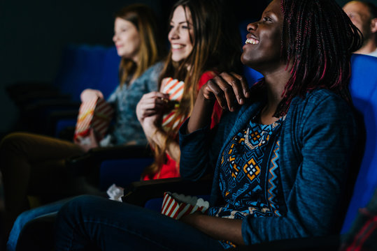 Smiling Black Woman Watching A Movie In Good Company At The Cinema