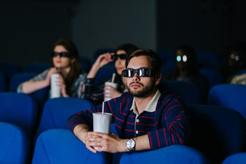 Multiracial people watching a movie with 3D glasses at the cinema