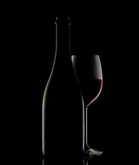 silhouette of a wine bottle and glass on black background