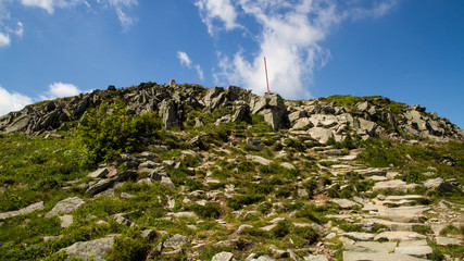 Babia gora mountain in Poland with stones, blue sky with white clouds plants