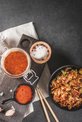 Asian cuisine. Fermented food. Traditional Korean dish: kimchi cabbage - sauerkraut with traditional kimchi sauce from hot red chili pepper, garlic, spices, salt. On a black stone table. Copy space