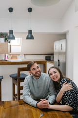 Happy couple sitting in the dining room of their new home