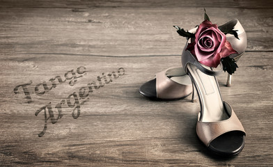 Argentine tango shoes and a rose on a wooden floor - obrazy, fototapety, plakaty