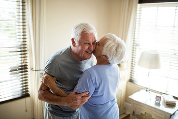 Senior couple embracing each other in bedroom