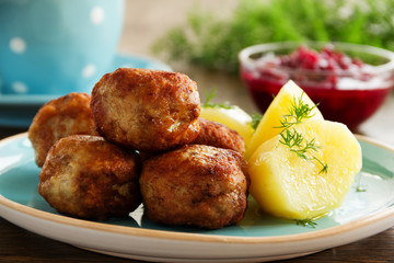Hot meatballs with boiled potatoes and cranberry sauce ..