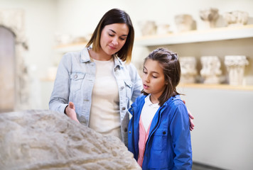 Mother and daughter exploring bas-reliefs in museum