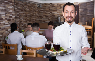 Waiter welcoming guests in restaurant
