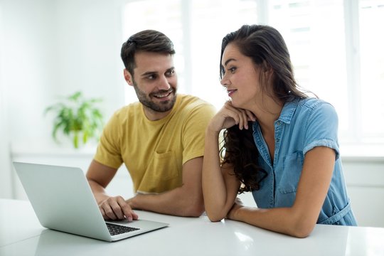 Couple using laptop in the kitchen