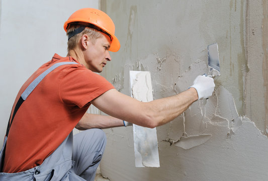 Worker is putting a gypsum plaste.