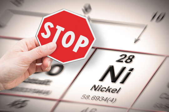 Stop heavy metals - Concept image with hand holding a stop sign against a Nickel chemical element with the Mendeleev periodic table on background