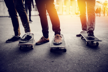 Boys skateboarders Feet in pants and bryaks in frayed sneakers stand on the skateboard. Concept of...