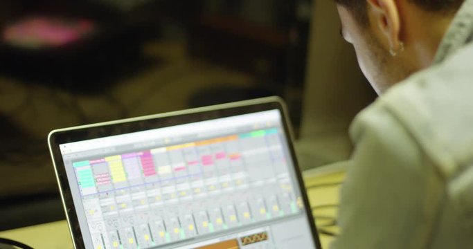 Musician/DJ making music on laptop at studio