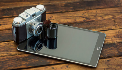 Vintage camera next to a tablet