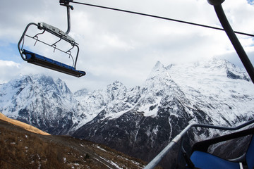view on cable car at ski resort and mountains in sunlight clouds. Caucasus Mountains, region Dombay