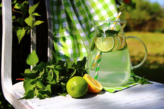 газированный лимонад в кувшине на стуле в саду 
