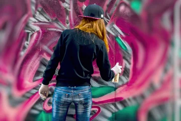 Poster Graffiti Une jeune fille urbaine dessine des graffitis, culture iconique contemporaine des jeunes de la rue. Rue de la culture urbaine emblématique moderne. Concept design moderne. Graffitis d& 39 art de rue. mise au point sélective