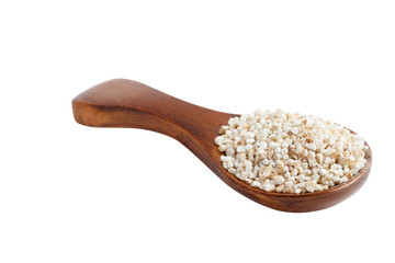 Barley groats on wooden spoon isolated on white background.