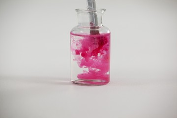 Paintbrush with pink paint dipped into a jar filled with water © WavebreakMediaMicro