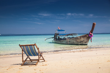 KO PHI PHI, THAILAND, February 2, 2014: Tropical beach with traditional long tail boats on the beach Mosquito island, Ko Phi Phi archiplago, Andaman Sea, famous tourist destination in Thailand