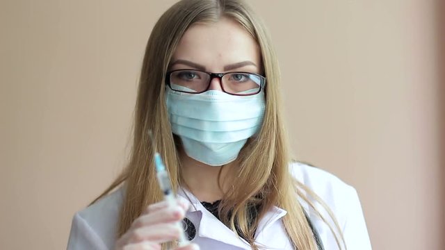A young female doctor prepares a syringe for injection. The concept of medicine