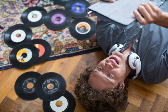 Musician listening to vinyls records and tablet