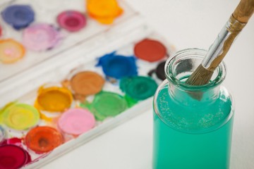 Watercolor palette and paint brush with blue paint