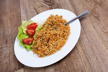 Vegetarian food on a plate with wooden background