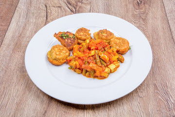 Vegetarian food on a plate with wooden background