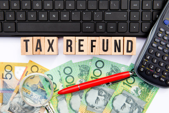 Tax Refund - Australia - wooden letters with keyboard, money and calculator
