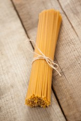 Bundle of raw spaghetti tied with white ribbon