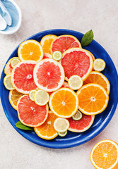 Variety  sliced citrus fruit orange, grapefruit, lemon on old blue black on a marble black white wooden board. Top view.
