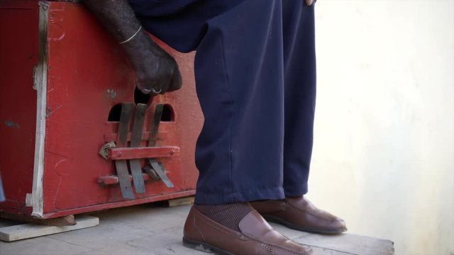 poor street musician playing the marimbula