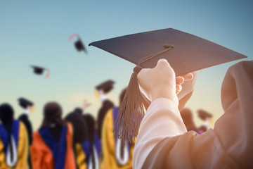 Graduates hold a congratulatory hat on campus.