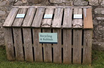 Wooden recycling and rubbish centre with labels for cans, plastics and general waste