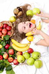 Fototapeta na wymiar child, cute baby girl laying with colorful fruits