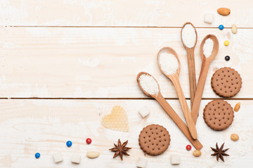 Obraz na płótnie Canvas Wooden spoons, cookies and candies on vintage background