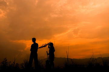 happy couple children playing on meadow at sunset, silhouette