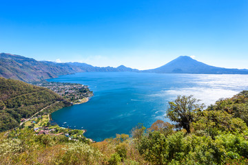 Naklejka na ściany i meble Panorama view to the village Panajachel at the lake Atitlan with amazing volcanos - Guatemala