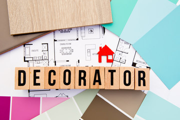 Decorator in block letters with house drawings, samples and house icon
