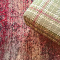 Checked textile hassock on a red carpet