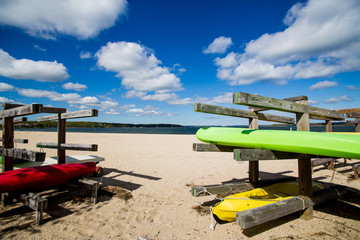 Colorful kayaks on wooden stands at the beach.Summer, outdoors, water sports and vacation concept 