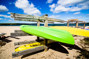 Colorful kayaks on wooden stands at the beach.Summer, outdoors, water sports and vacation concept 