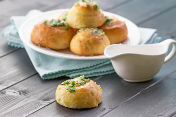 Homemade Garlic Knots and Sauce on the black wooden background. Garlic knot. Garlic bread.