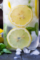 Sassy water. Lemonade. Refreshing cold drink with mint, cucumber, lemons. Sliced lemons with mint in mason jar  filled with ice and water. Mojito. Every day drink.