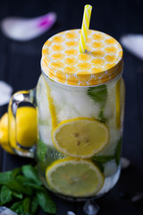 Lemonade. Sassy water. Refreshing cold drink with mint, cucumber, lemons. Sliced lemons with mint in mason jar  filled with ice and water. Mojito. Every day drink.